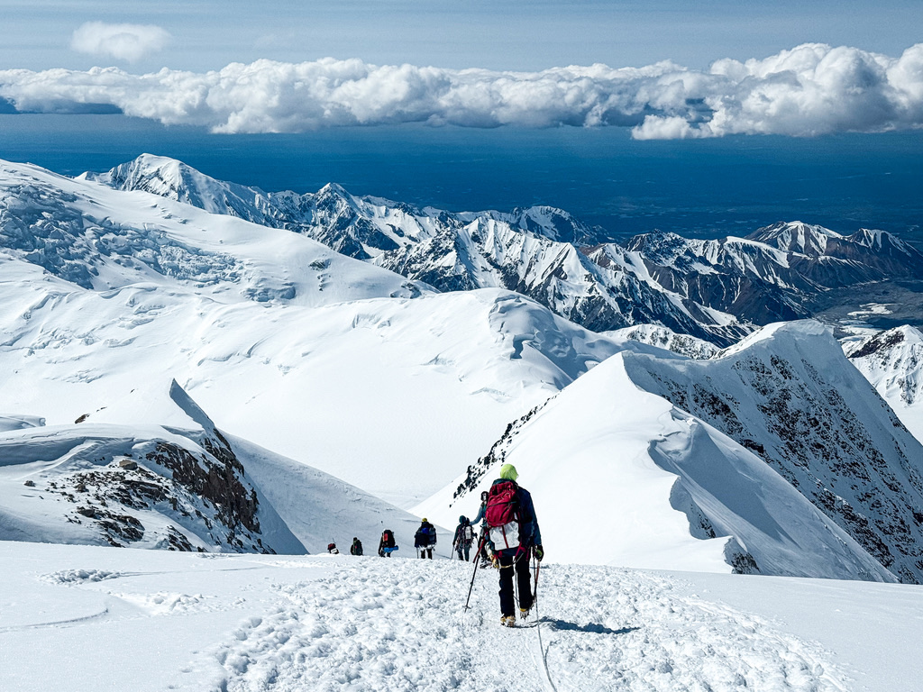 A rope team climbing the West Buttress ridge on Denali, high above the Alaska Range